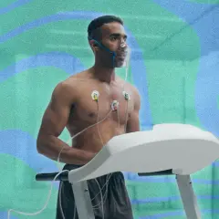 Un homme court sur un tapis roulant, portant un masque à oxygène et des électrodes. Il teste son endurance pour savoir combien de temps pour augmenter sa VO2 max.