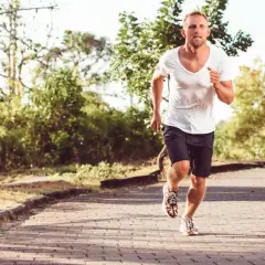 Homme courant sur un chemin pavé, le souffle court, peut-être à cause d'un vo2 max faible.