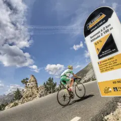 Cycliste en ascension au col d'Izoard, panneau indiquant l'altitude et la pente.
