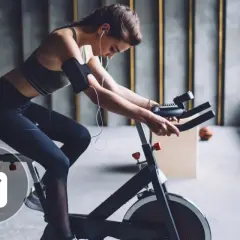 Femme en tenue de sport faisant du spinning, un sport qui aide à perdre du poids.