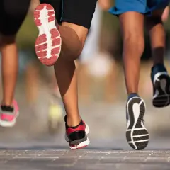 Des coureurs en action, leurs pieds chaussés de baskets dynamiques, illustrent parfaitement l'élan pour apprendre à courir.
