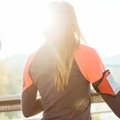 Deux femmes s'entraînent dehors, profitant du soleil. L'une porte un brassard pour son téléphone, prête à courir sous 30 degrés.