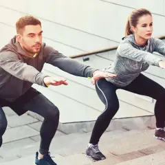 Un couple fait des squats sur des marches, un excellent exercice pour perdre du poids.