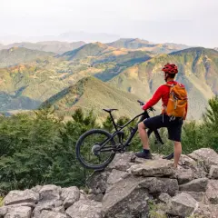 Un cycliste admire le paysage montagneux après une belle balade VTT.
