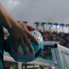 Main tenant une balle de cecifoot, prêt pour le match. Les règles du jeu sont claires, l'excitation monte dans le stade.