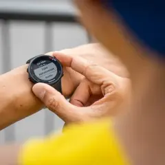 Main tenant de son Garmin Forerunner 45s, il prépare son entraînement de natation.
