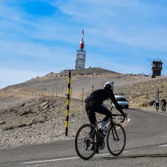 Cycliste sur la route du Mont Ventoux, près de Bédoin. Le sommet avec sa tour de télécommunication se dresse au loin.