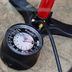 Manomètre de pompe à vélo affichant la pression pneu vtc. Le cadran indique environ 4 bars.