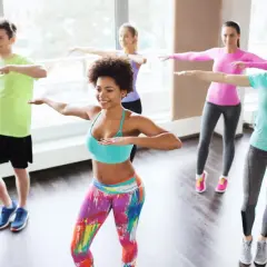 Groupe joyeux en cours de zumba pour maigrir, dansant avec énergie et sourires.