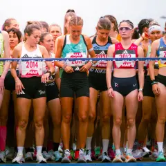 Des coureuses prêtes à courir un semi marathon, visages concentrés, dossards affichés.
