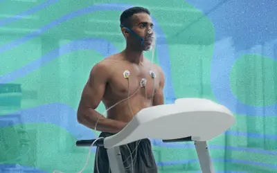 Un homme court sur un tapis roulant, portant un masque à oxygène et des électrodes. Il teste son endurance pour savoir combien de temps pour augmenter sa VO2 max.