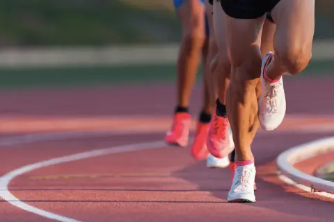 Course de vitesse sur piste, les jambes des athlètes en pleine action, vma def.