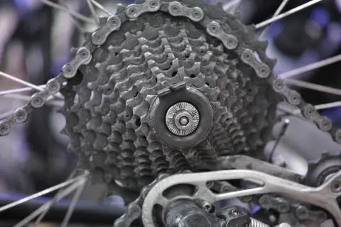 Détail d'une cassette de vélo, prête à être démontée. Les pignons et la chaîne sont visibles.