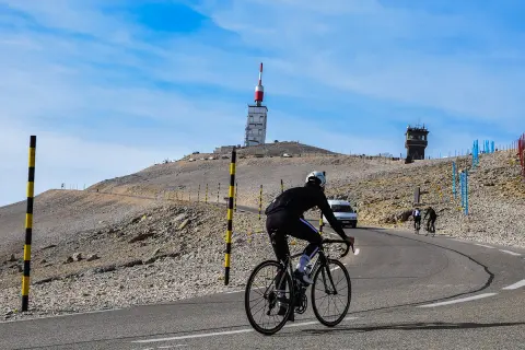 Cycliste sur la route du Mont Ventoux, près de Bédoin. Le sommet avec sa tour de télécommunication se dresse au loin.