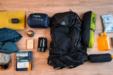 Sac à dos, sac de couchage, tente, réchaud, gourde, vêtements et nourriture : tout le nécessaire pour le camping.