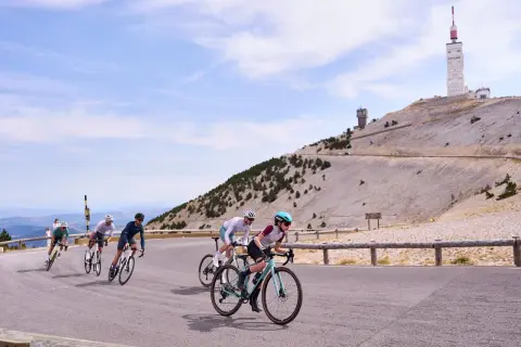 Cyclistes gravissant le Mont Ventoux, avec sa tour emblématique en arrière-plan.