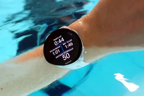 Montre Garmin Forerunner 55 en action pour la natation, affichant le temps d'intervalle et la distance.