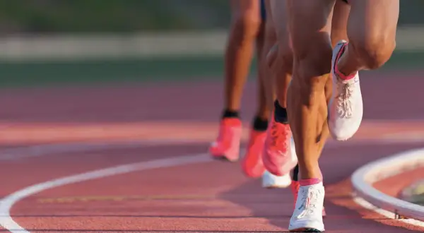 Course de vitesse sur piste, les jambes des athlètes en pleine action, vma def.