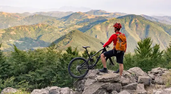 Un cycliste admire le paysage montagneux après une belle balade VTT.