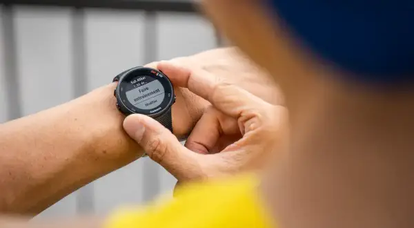Main tenant de son Garmin Forerunner 45s, il prépare son entraînement de natation.