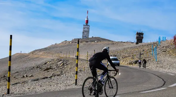 Cycliste sur la route du Mont Ventoux, près de Bédoin. Le sommet avec sa tour de télécommunication se dresse au loin.