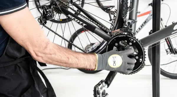 Maintenant, je vais démonter le pédalier de ce VTT. L'outil est bien en place sur la manivelle.