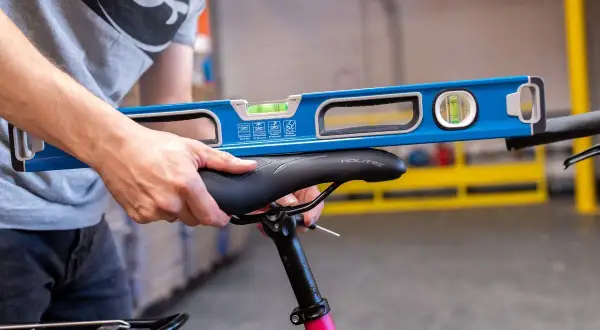 Ajustement précis de la hauteur de selle vélo avec un niveau à bulle pour un confort optimal.
