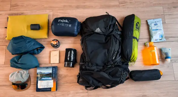 Sac à dos, sac de couchage, tente, réchaud, gourde, vêtements et nourriture : tout le nécessaire pour le camping.