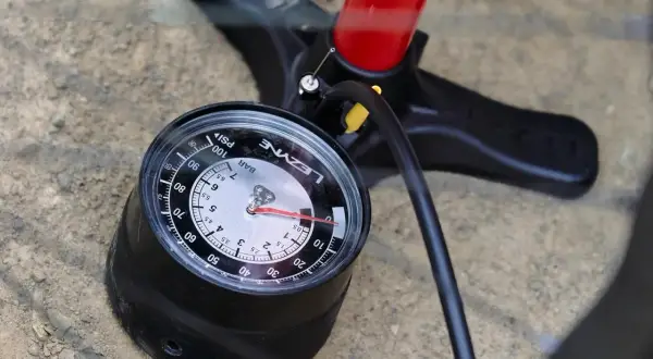 Manomètre de pompe à vélo affichant la pression pneu vtc. Le cadran indique environ 4 bars.