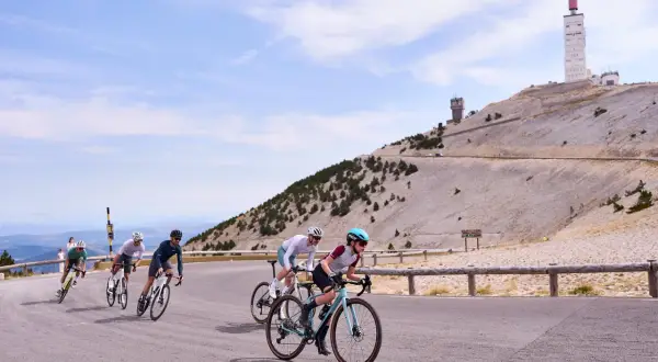 Cyclistes gravissant le Mont Ventoux, avec sa tour emblématique en arrière-plan.