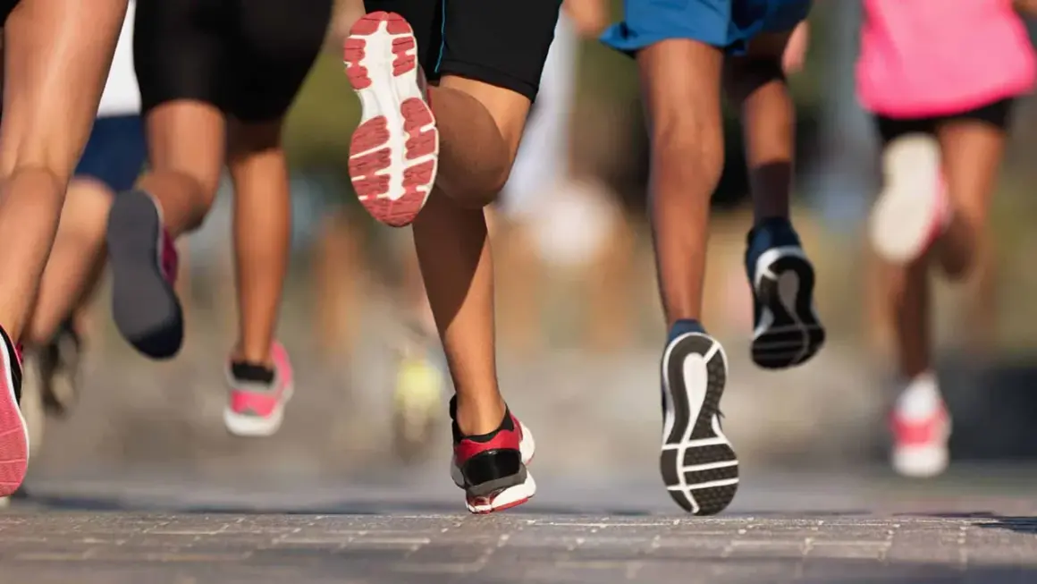 Des coureurs en action, leurs pieds chaussés de baskets dynamiques, illustrent parfaitement l'élan pour apprendre à courir.