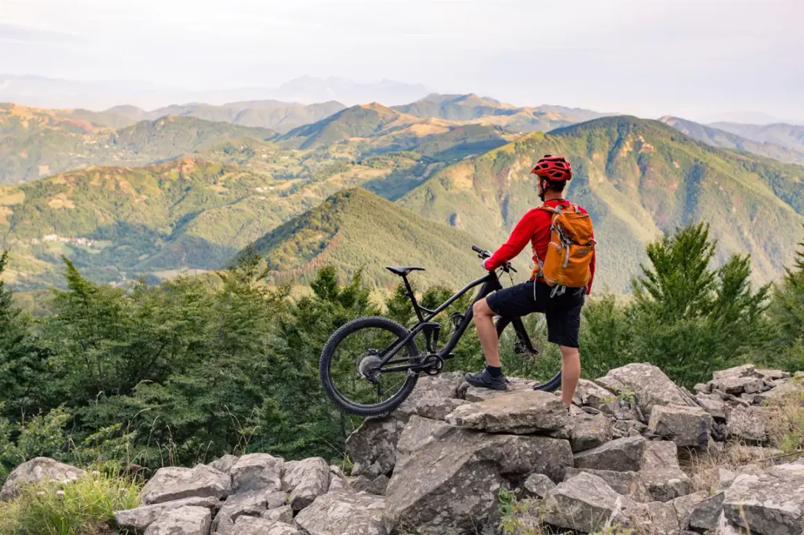 Un cycliste admire le paysage montagneux après une belle balade VTT.
