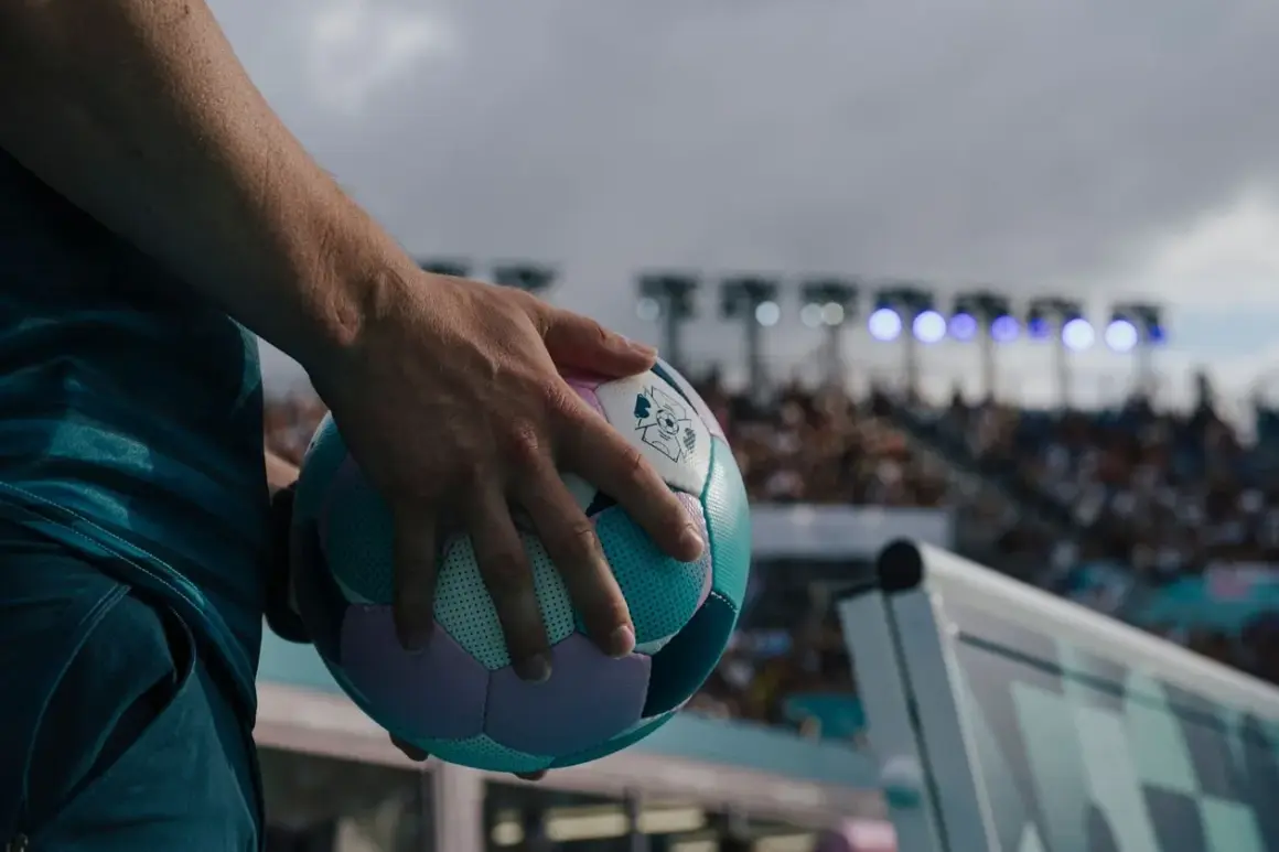 Main tenant une balle de cecifoot, prêt pour le match. Les règles du jeu sont claires, l'excitation monte dans le stade.