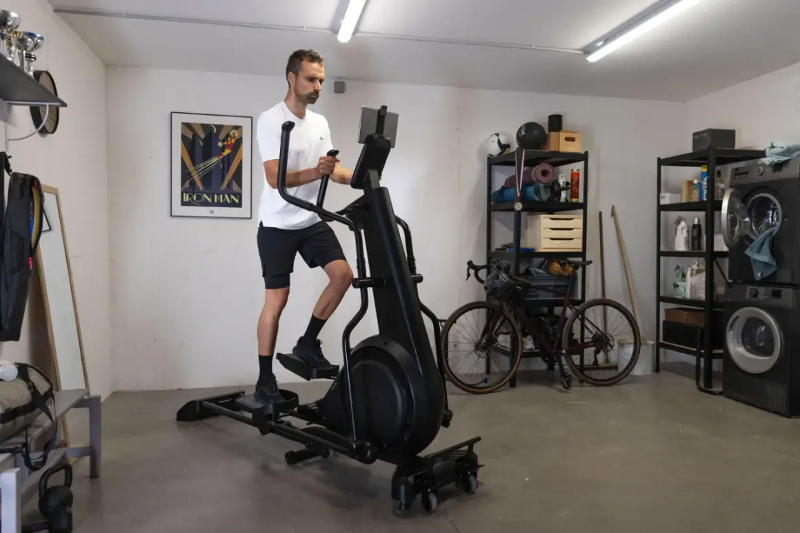 Homme s'entraînant sur un vélo elliptique pour la perte de poids dans un garage aménagé.