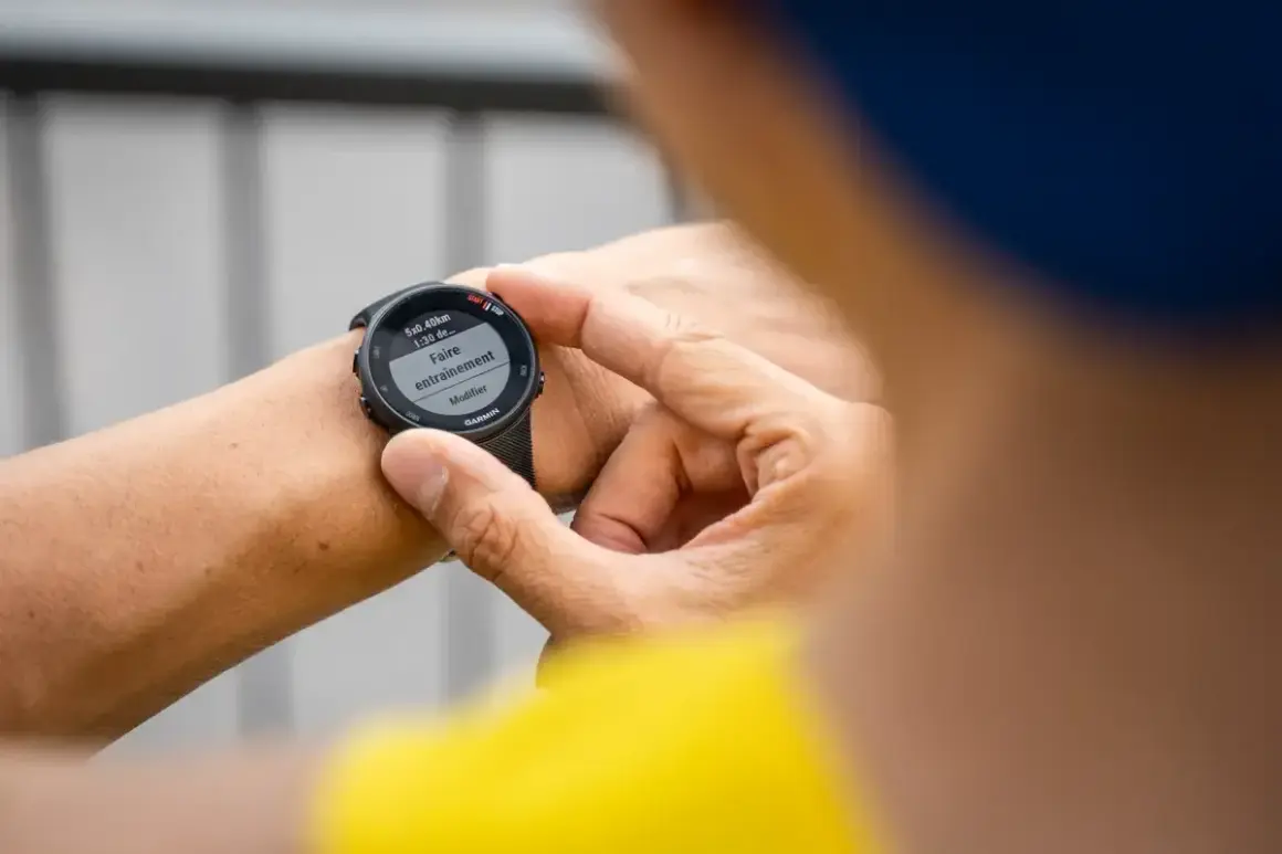 Main tenant de son Garmin Forerunner 45s, il prépare son entraînement de natation.