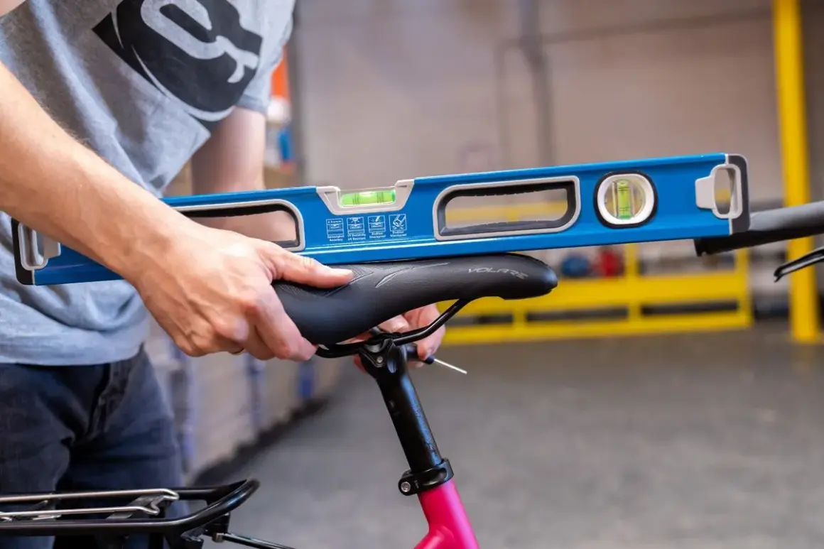 Ajustement précis de la hauteur de selle vélo avec un niveau à bulle pour un confort optimal.