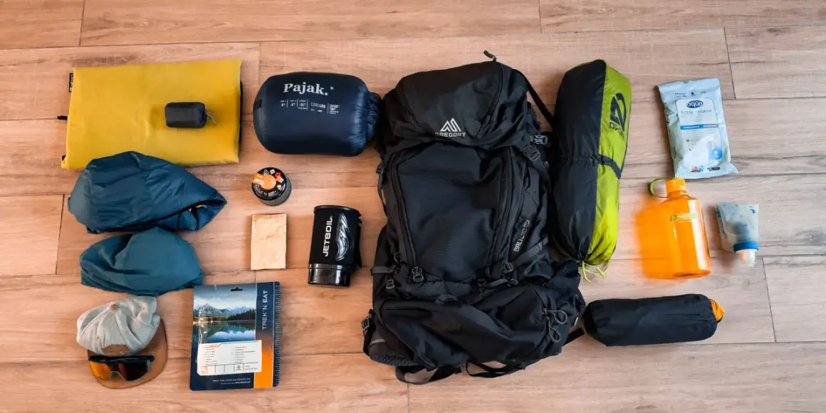 Sac à dos, sac de couchage, tente, réchaud, gourde, vêtements et nourriture : tout le nécessaire pour le camping.