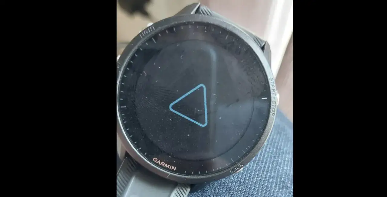 Montre Garmin avec un triangle bleu stylis&eacute; au centre de l'&eacute;cran, pr&ecirc;t &agrave; lancer une activit&eacute;.