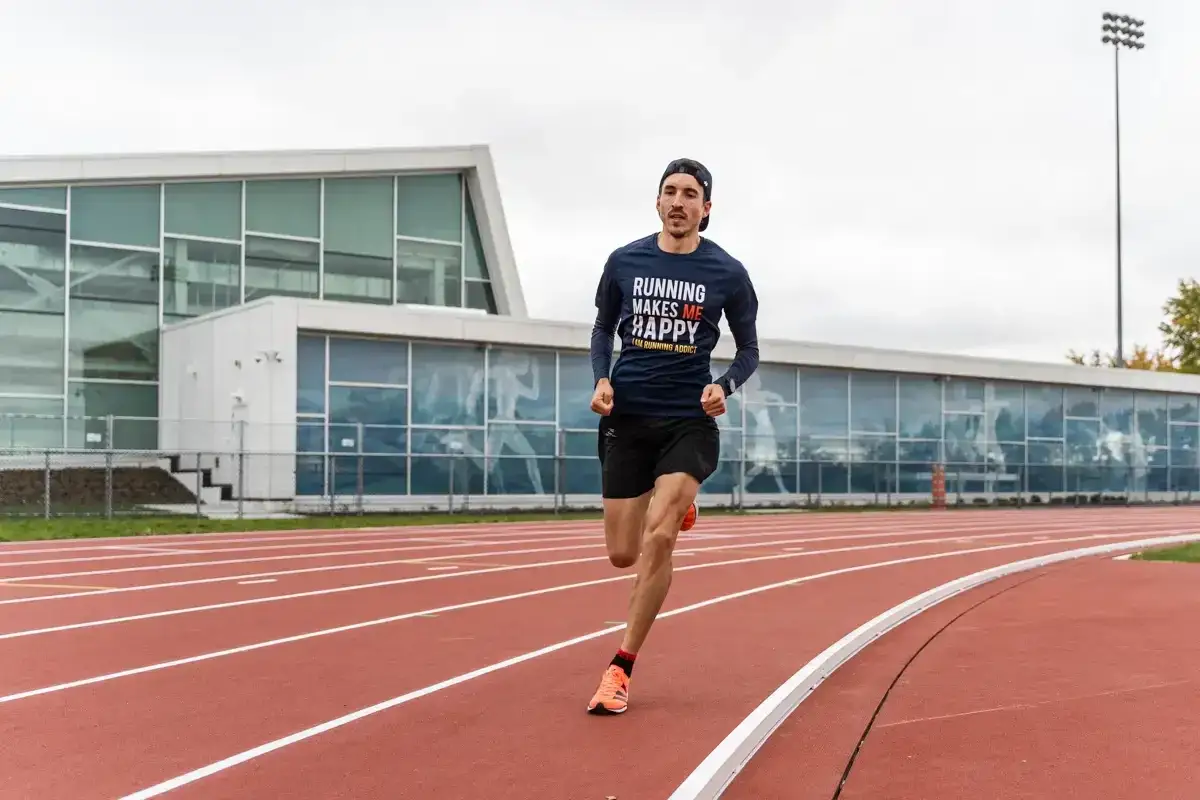 Un coureur sur une piste d'athlétisme, effectuant un test VMA. Il porte un t-shirt 