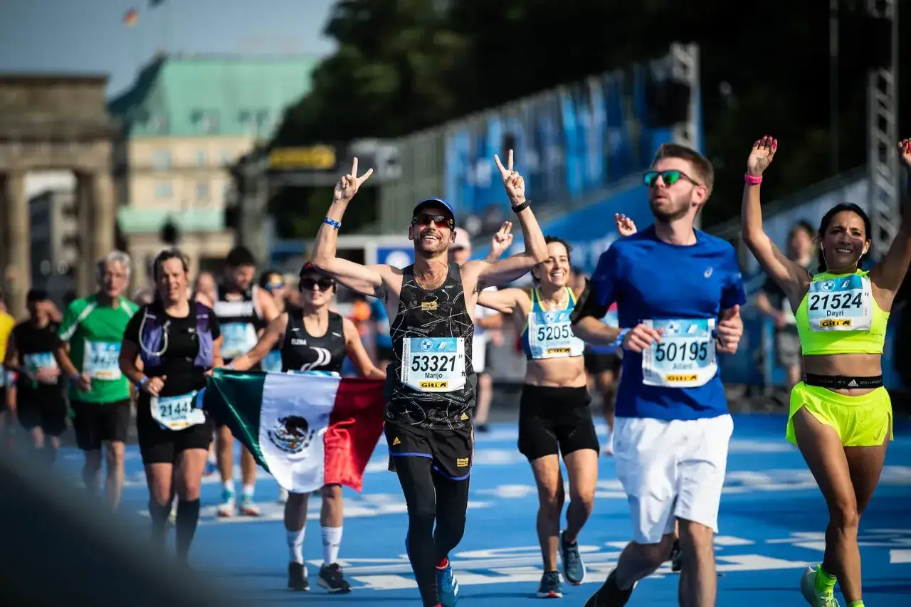 Coureurs c&eacute;l&eacute;brant leur victoire lors d'un marathon, possiblement l'un des World Marathon Majors, avec le drapeau mexicain.