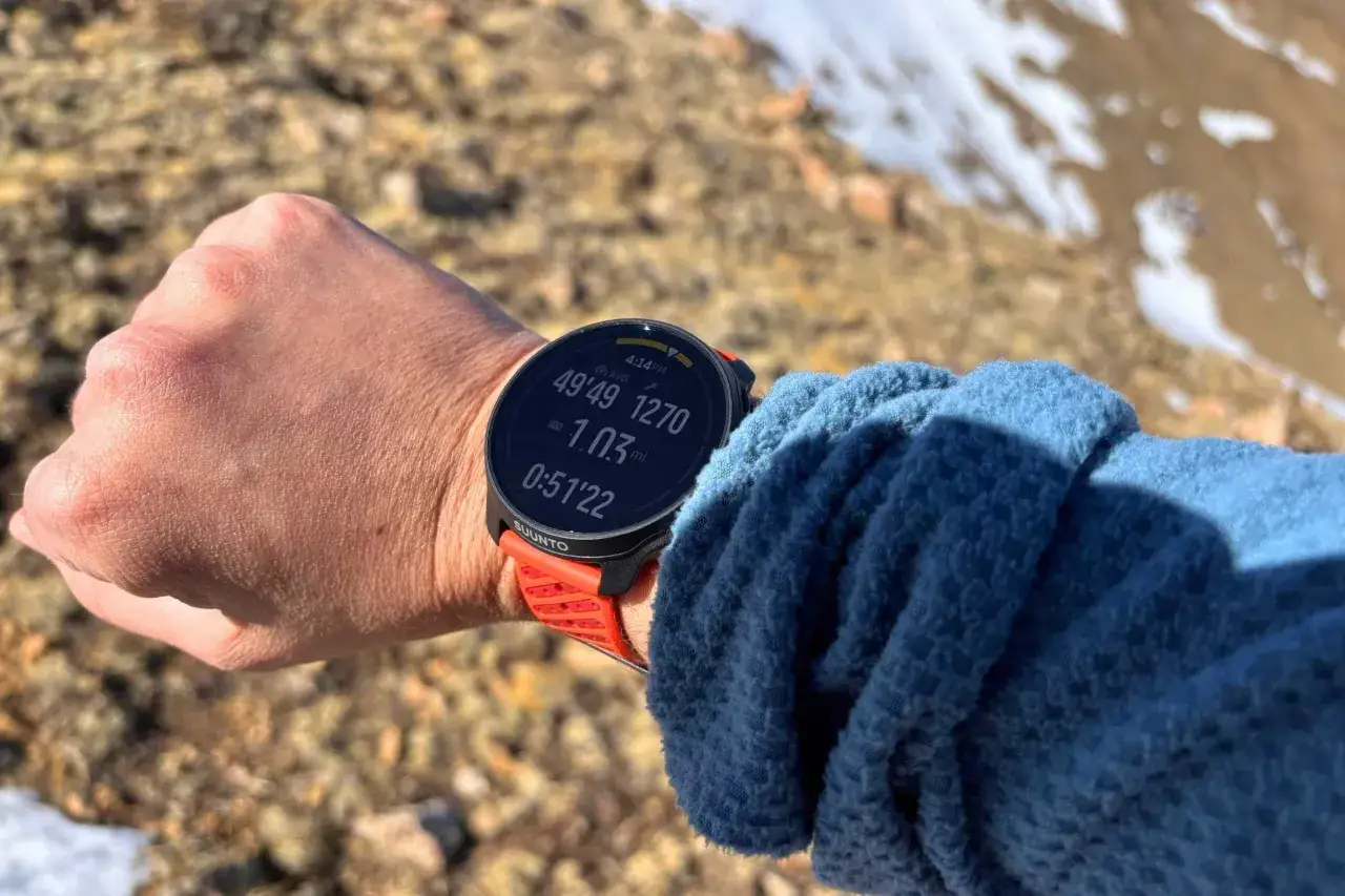 Poignet portant une montre Suunto affichant le livetrack, avec des donn&eacute;es d'activit&eacute; et l'heure.