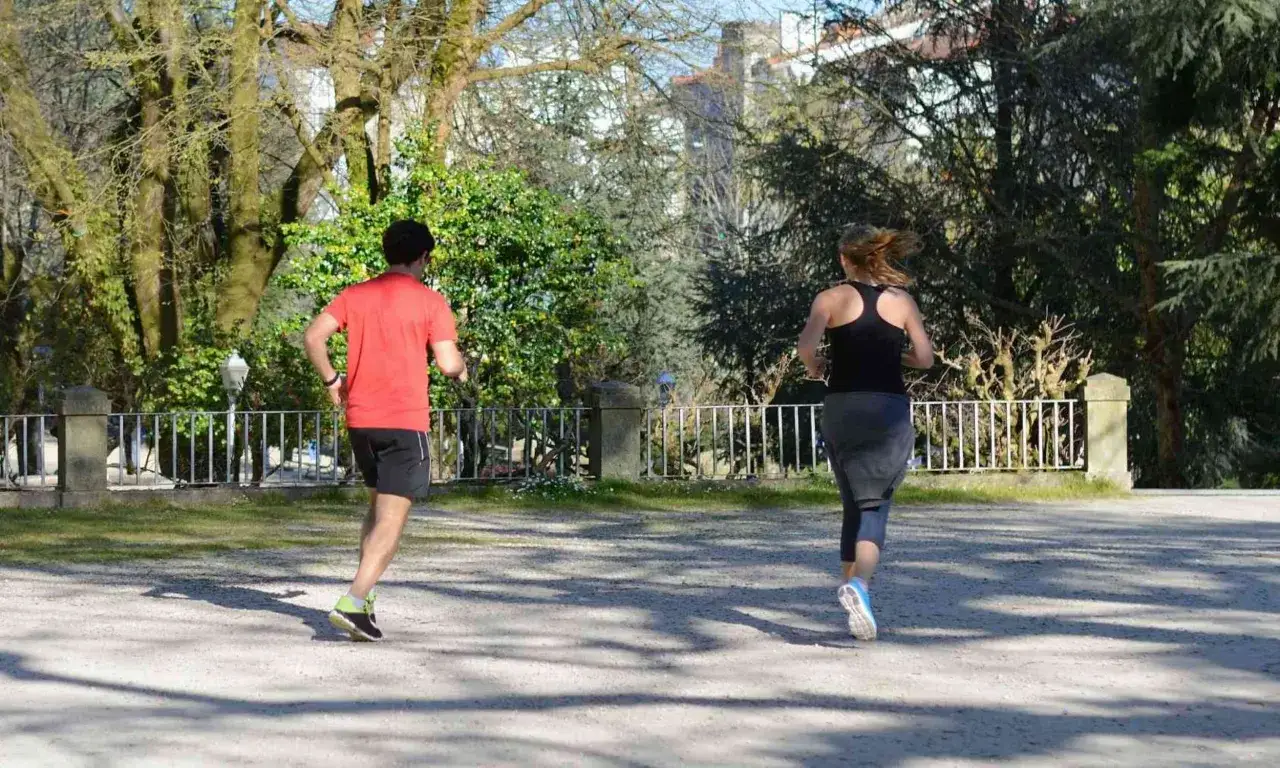 Un homme et une femme courent dans un parc, profitant de l'air frais. Ils semblent d&eacute;termin&eacute;s &agrave; courir sous 30 degr&eacute;s, d&eacute;fiant la chaleur pour leur entra&icirc;nement.