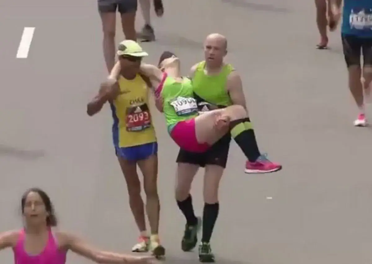 Un coureur aide un autre, visiblement &eacute;puis&eacute;, &agrave; franchir le mur du marathon. L'esprit d'&eacute;quipe prime.