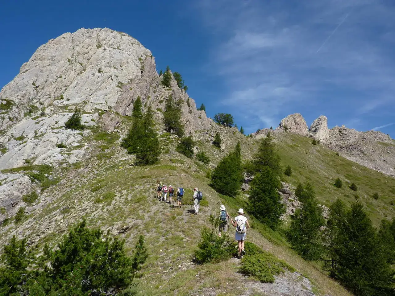Randonneurs sur un sentier escarp&eacute;, le tour du Queyras r&eacute;v&egrave;le sa difficult&eacute;. Paysage montagneux, ciel bleu.