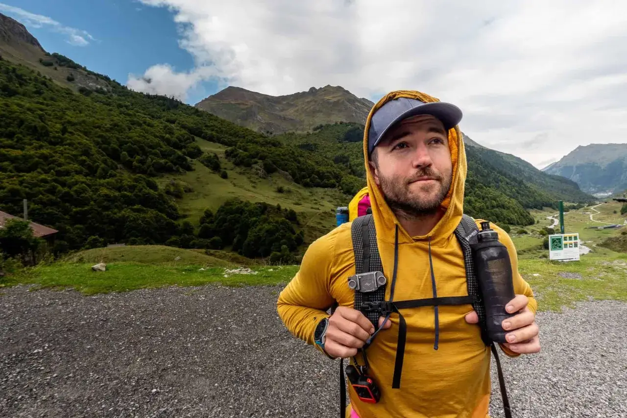 Randonneur prêt pour le bivouac, sac à dos chargé, gourde à la main. La liste matériel bivouac est prête pour l'aventure en montagne.