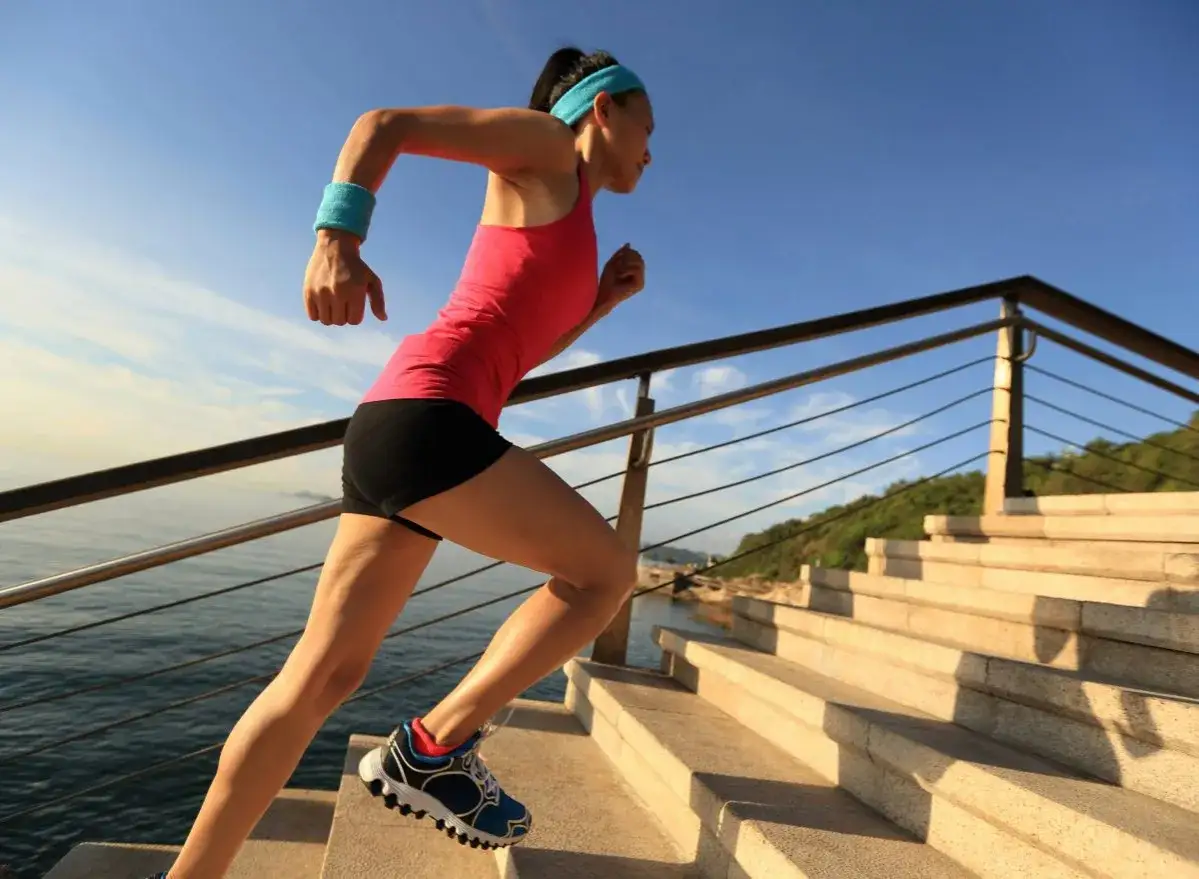 Femme courant dans les escaliers, un entra&icirc;nement cardio intense. Le sport le plus cardio pour un corps tonique.