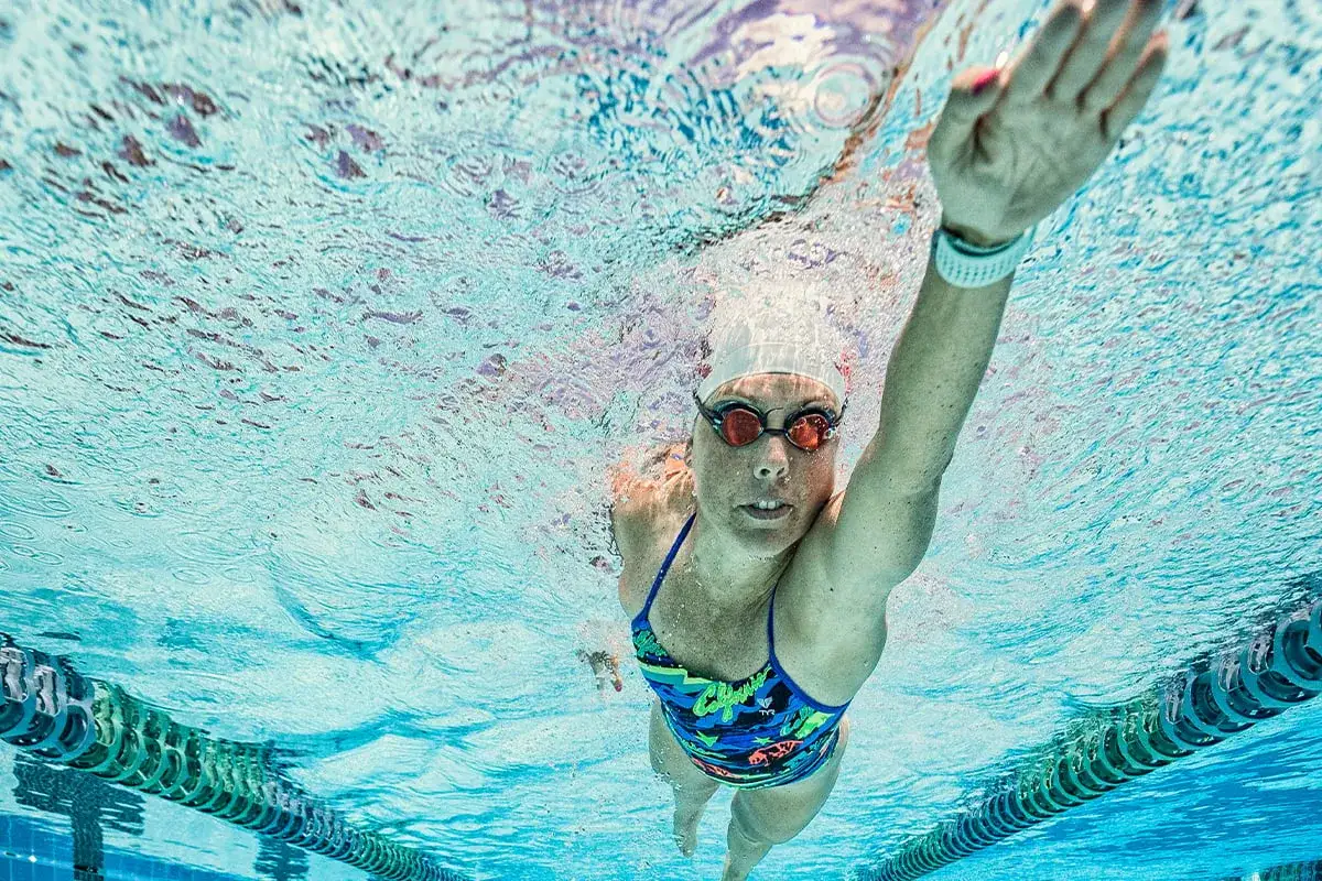 Plongeuse en crawl, portant un Garmin Forerunner 55 pour suivre sa natation.