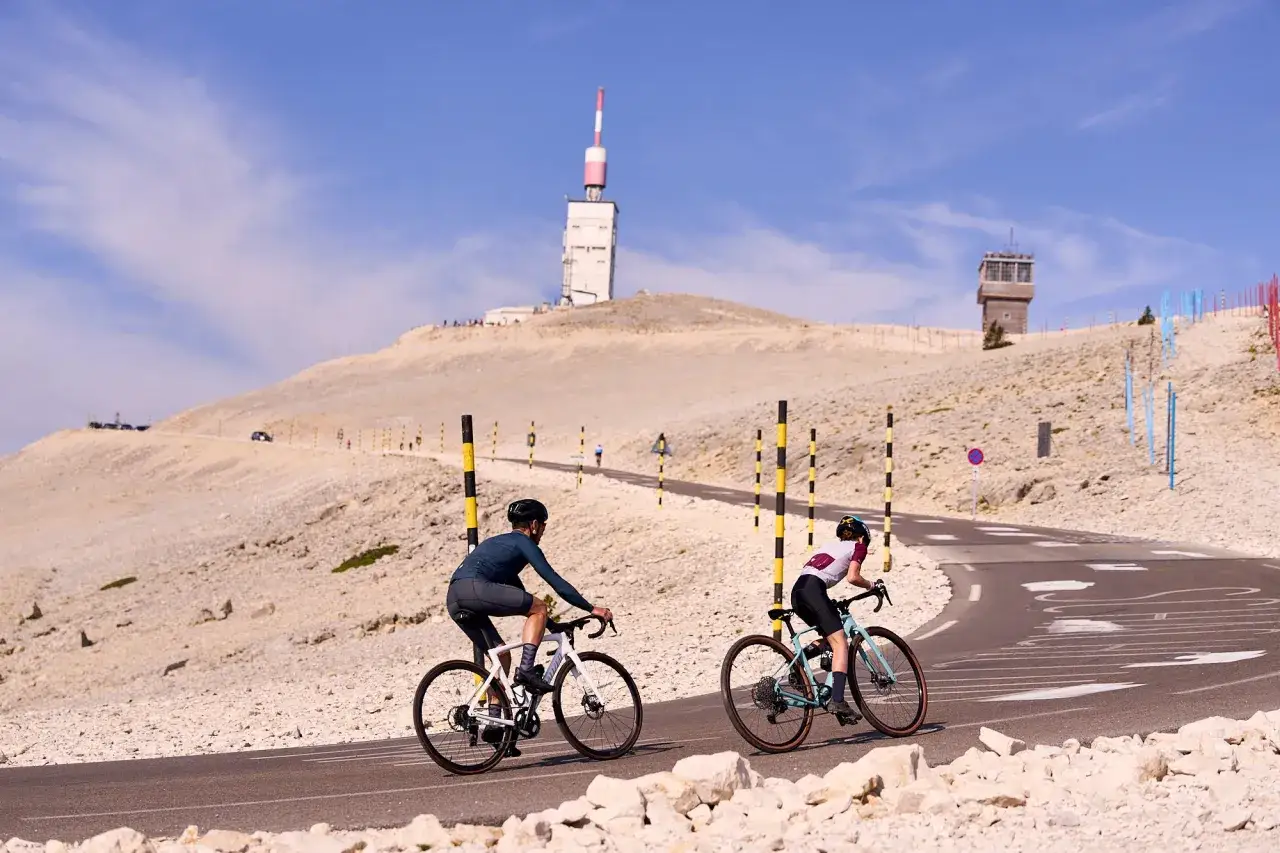 Cyclistes gravissant le Mont Ventoux par Malaucène, avec la tour de l'émetteur en arrière-plan.