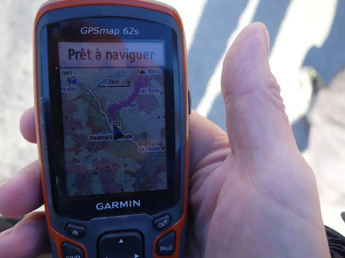 Un appareil Garmin GPSmap 62s affiche une carte avec un itinéraire. Le message 