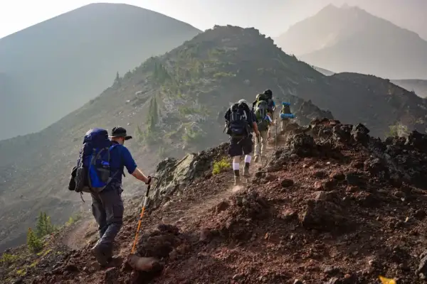 Un groupe de randonneurs progresse sur un sentier rocailleux, profitant d'un paysage randonnée montagne spectaculaire.